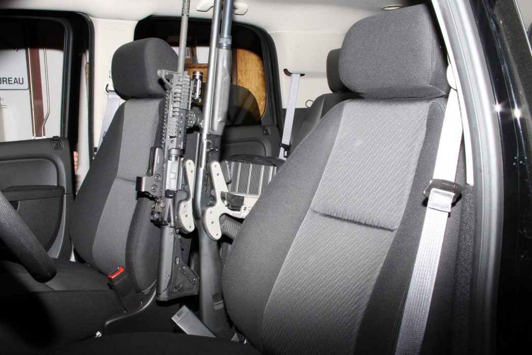 using a freestand two blac-racs are securing a shotgun and rifle in a suv police cruiser