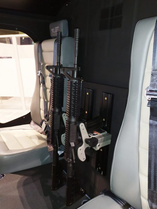 dual 1082 gun racks are mounted between cabin seats in a helicopter